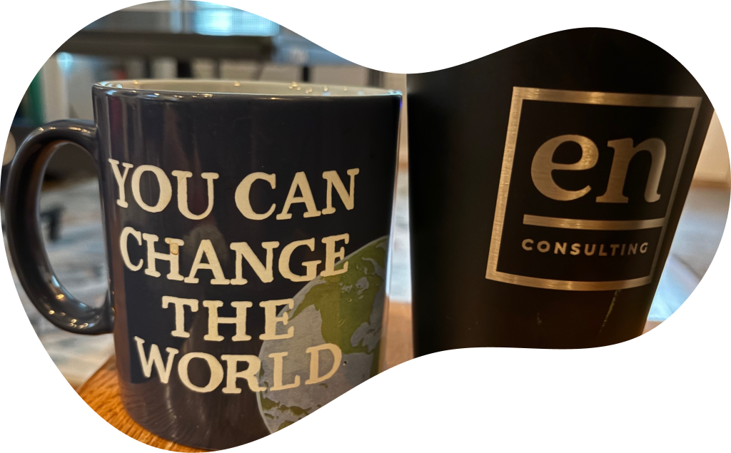 Mug with the quote 'You can change the world' next to an En Dash branded drinking vessel